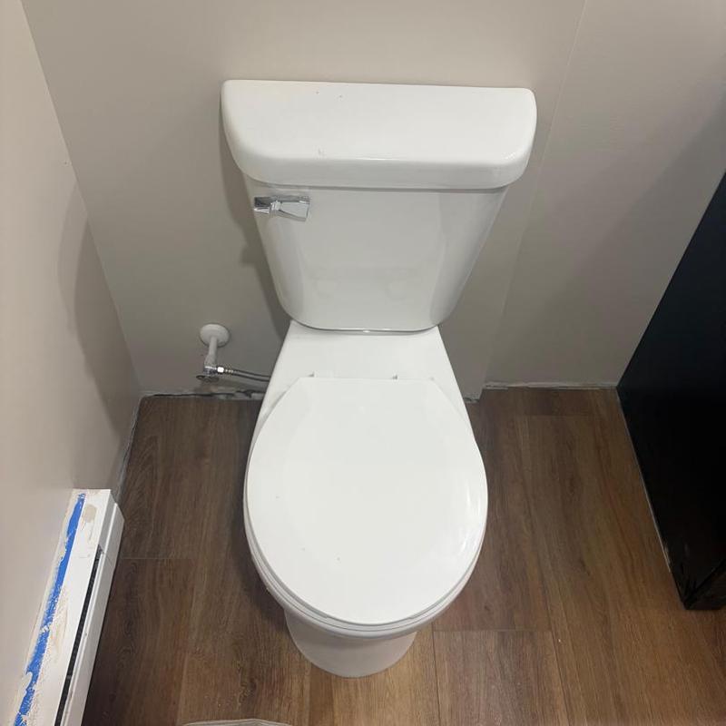 Toilet installation in bathroom remodel with wood floor