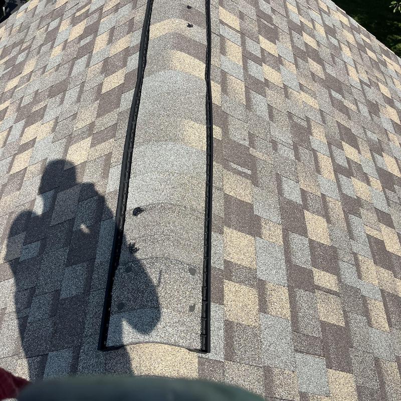 Ridge cap shingles on asphalt shingle roof with shadow Ridge cap shingles on asphalt shingle roof with shadow