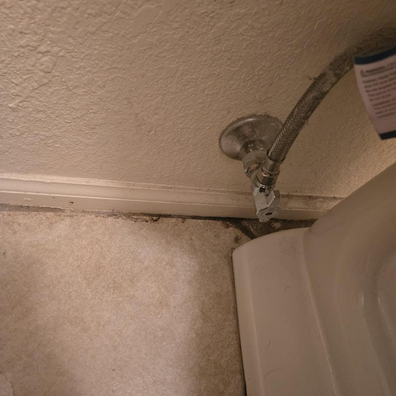 Toilet water supply line and valve near baseboard