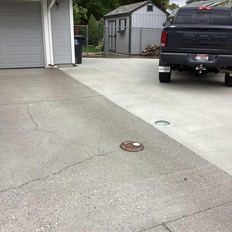 Concrete driveway with water meter and truck parked Concrete driveway with water meter and truck parked