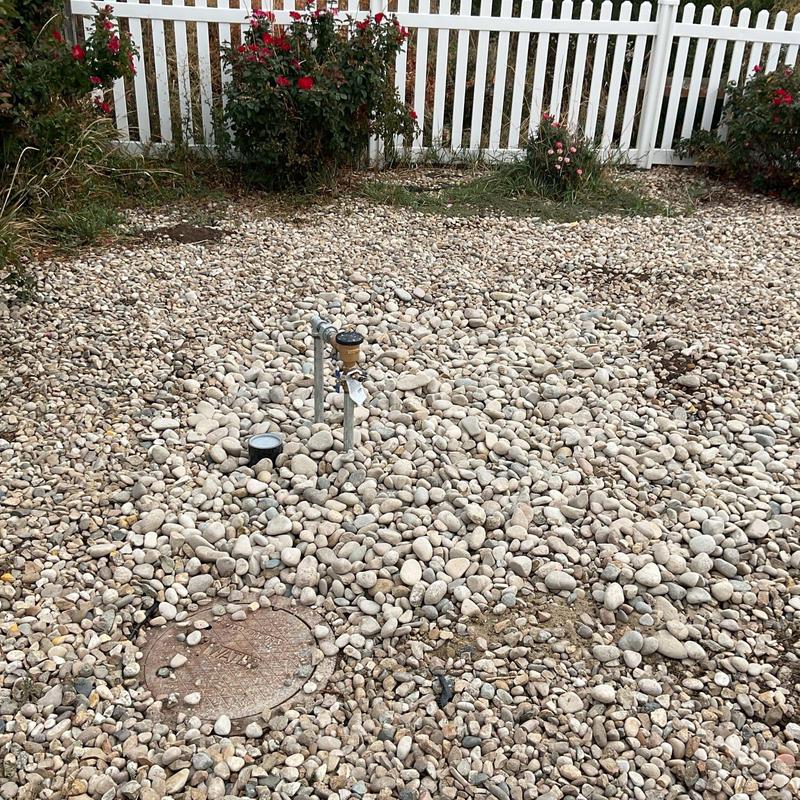Water meter and split pipe installation in gravel yard Water meter and split pipe installation in gravel yard