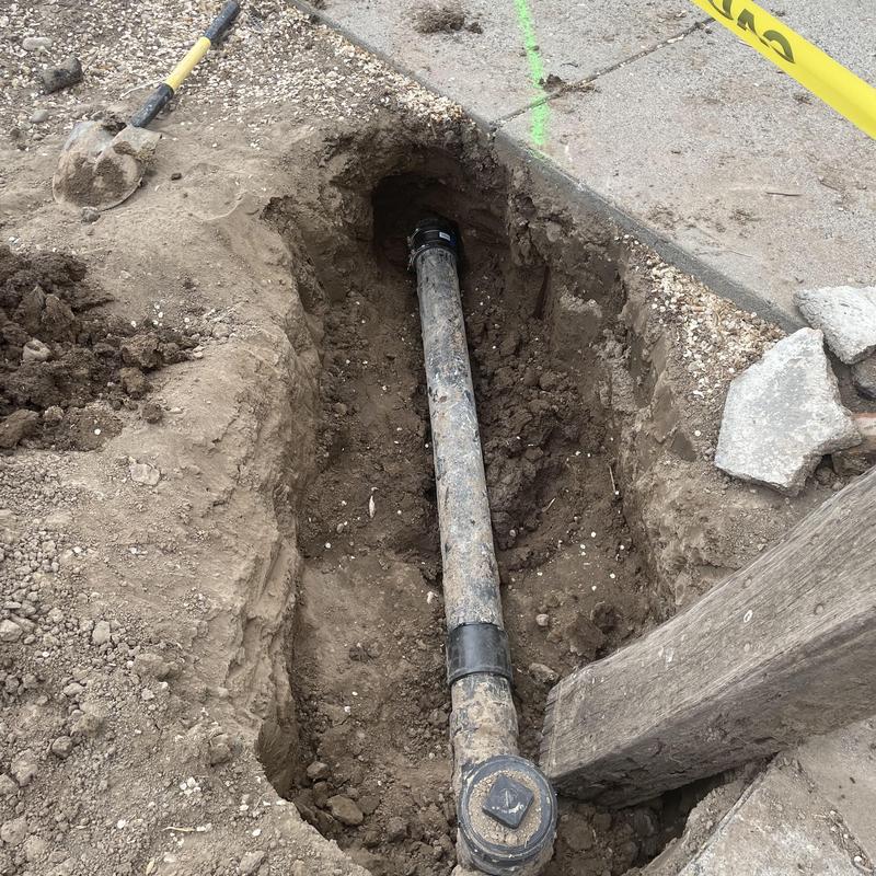 City sewer mainline pipe exposed in dug trench City sewer mainline pipe exposed in dug trench