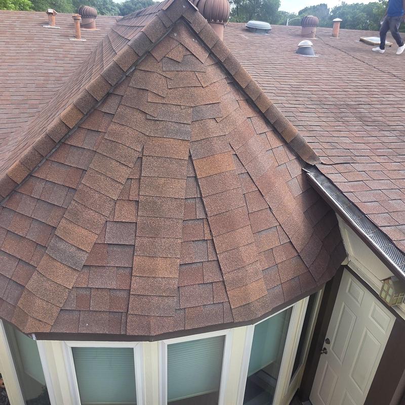 Asphalt shingle roof on turret after hail damage