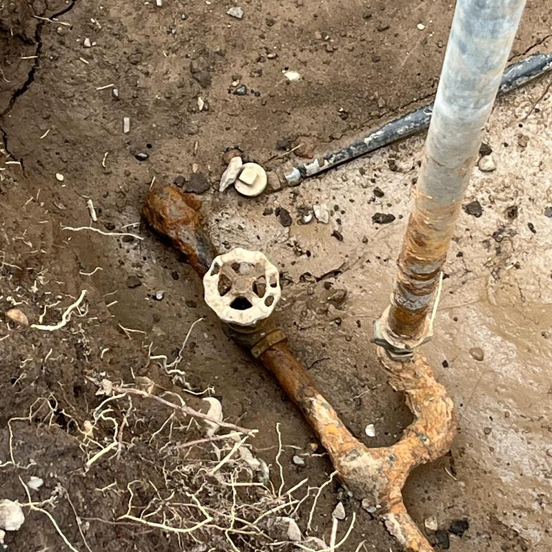 Rusty curb stop valve and yard hydrant piping in soil Rusty curb stop valve and yard hydrant piping in soil