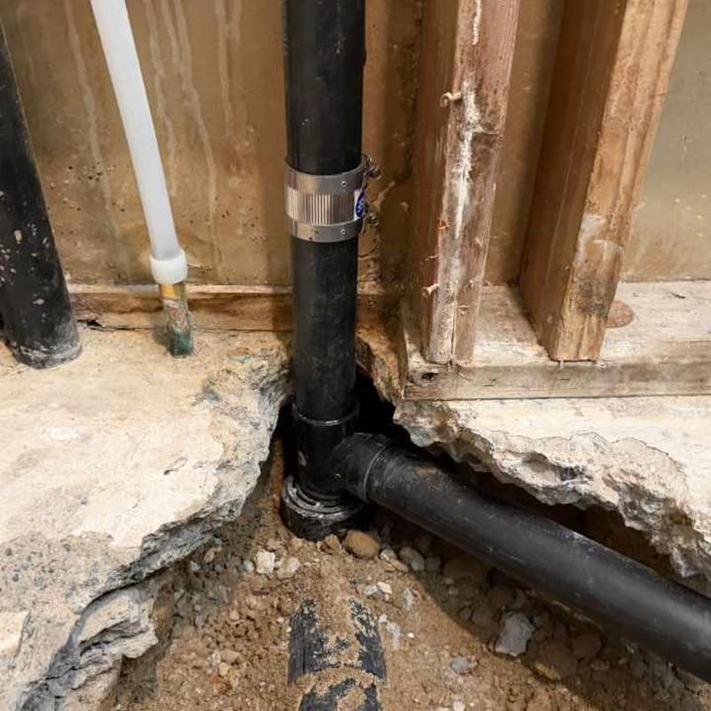 Toilet rough-in plumbing with pipe relocation in concrete floor