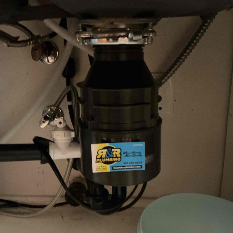 Garbage disposal unit with plumbing connections installed