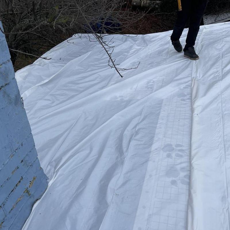 Torch down roofing membrane installation on low pitch roof