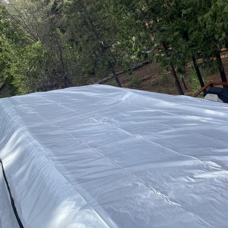Roof tarp covering cabin roof during replacement job