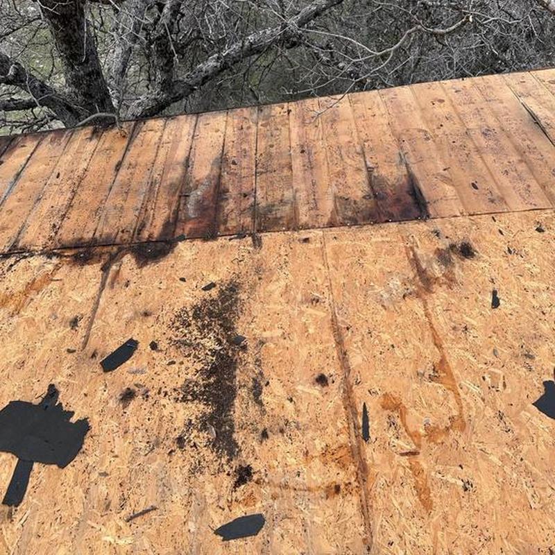 Asphalt roof deck with water damage and debris