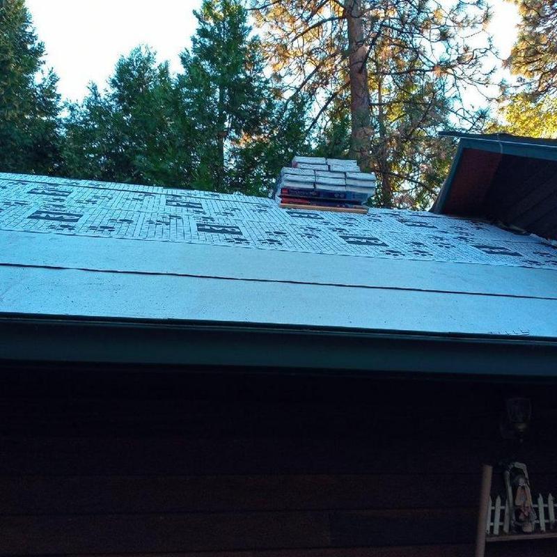 Asphalt roof underlayment installation on cabin roof