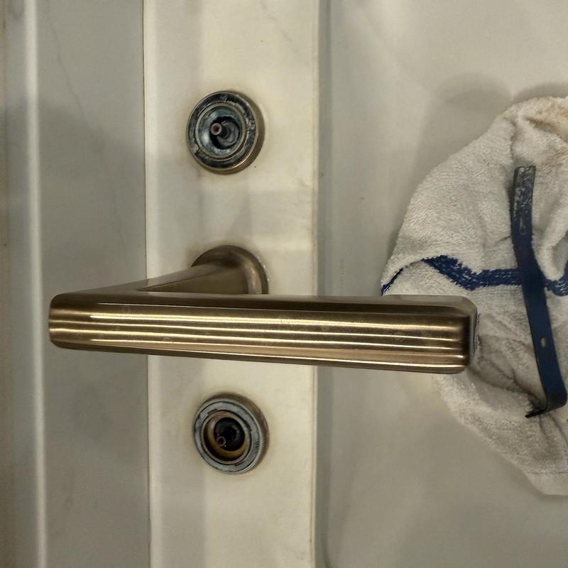 Door handle with exposed lock cylinders and towel nearby