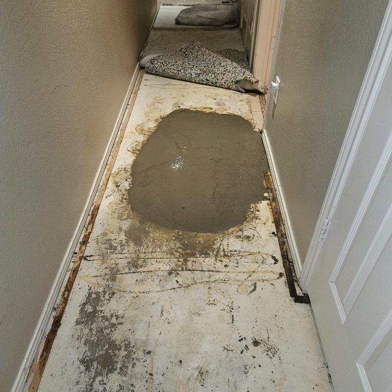 Concrete slab patch in hallway after plumbing repair