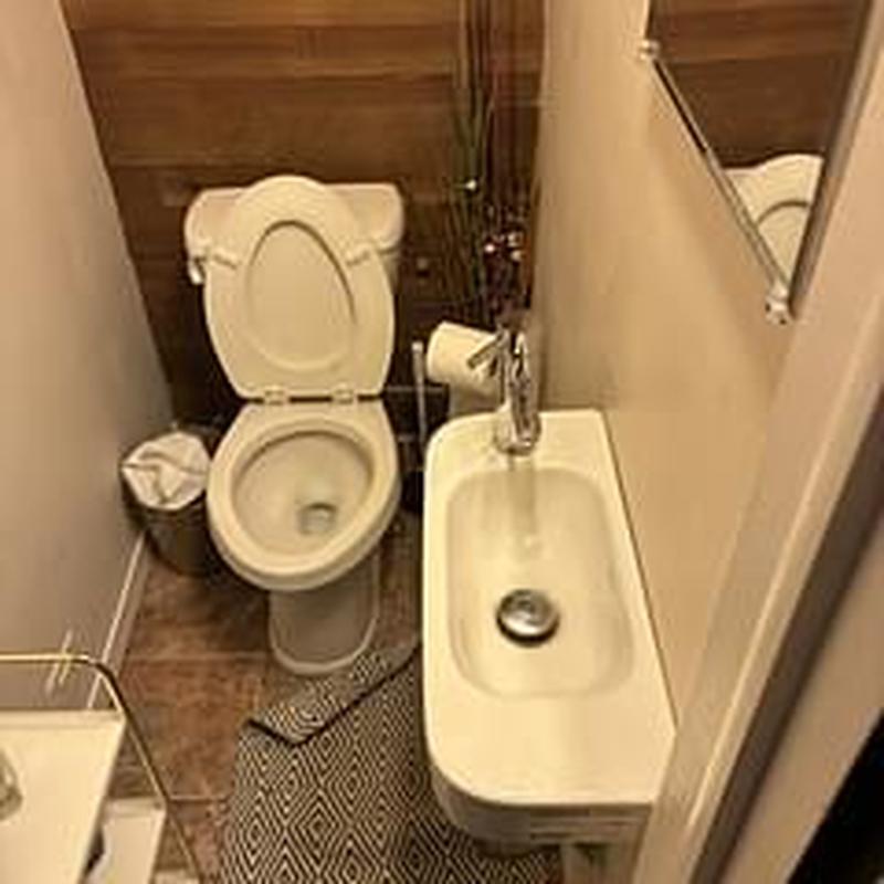 Lavatory sink drain with toilet in small bathroom
