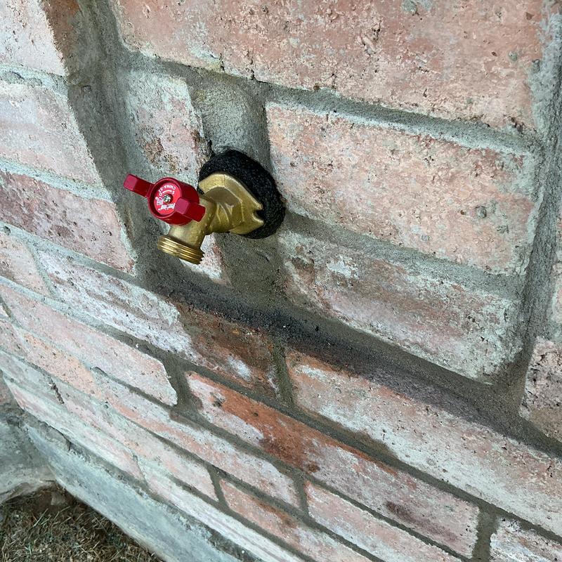 14-turn hose bib installed on brick wall exterior