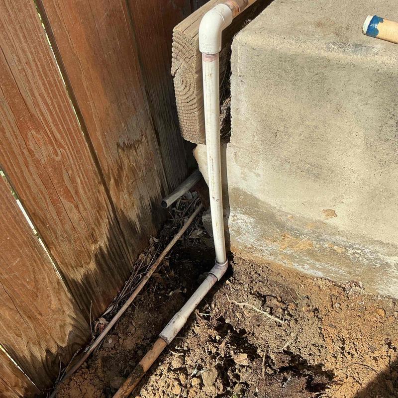 12-inch PVC pipe replacement near fence and foundation