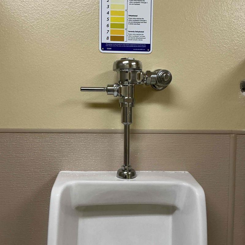 Sloan flush valve installed on urinal