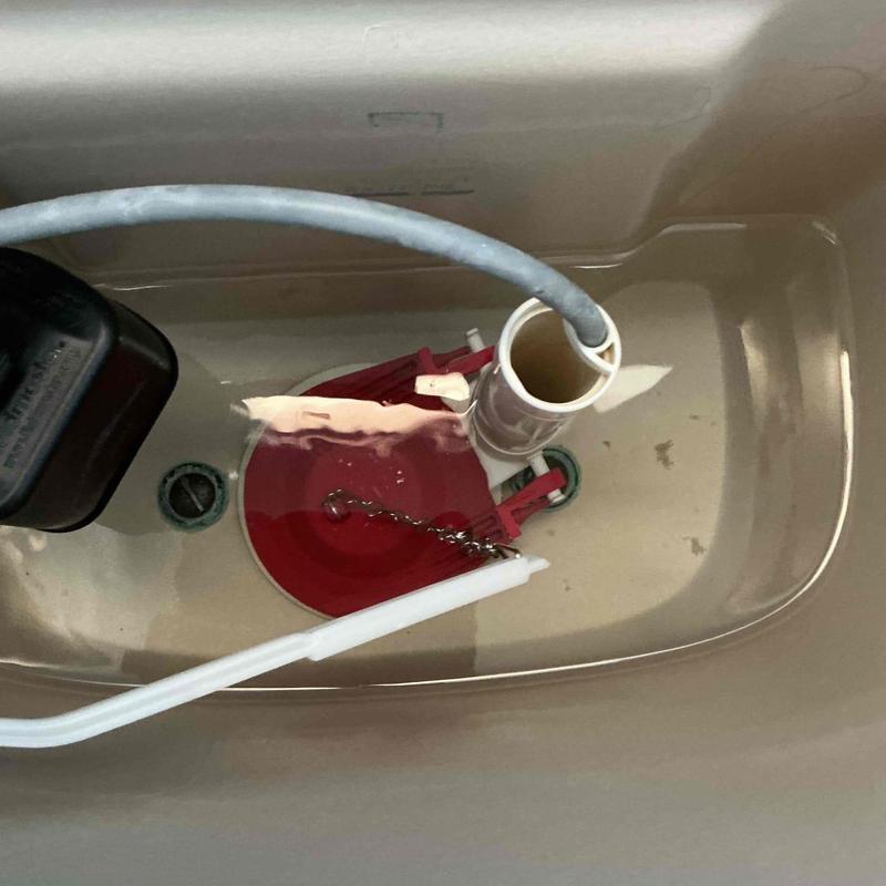 Toilet tank with red triple flapper valve installed