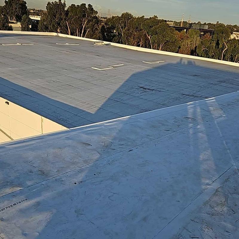 Flat roof surface with repaired membrane patches Flat roof surface with repaired membrane patches