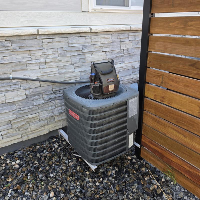 Goodman GSX13 air conditioner with tool bag on top