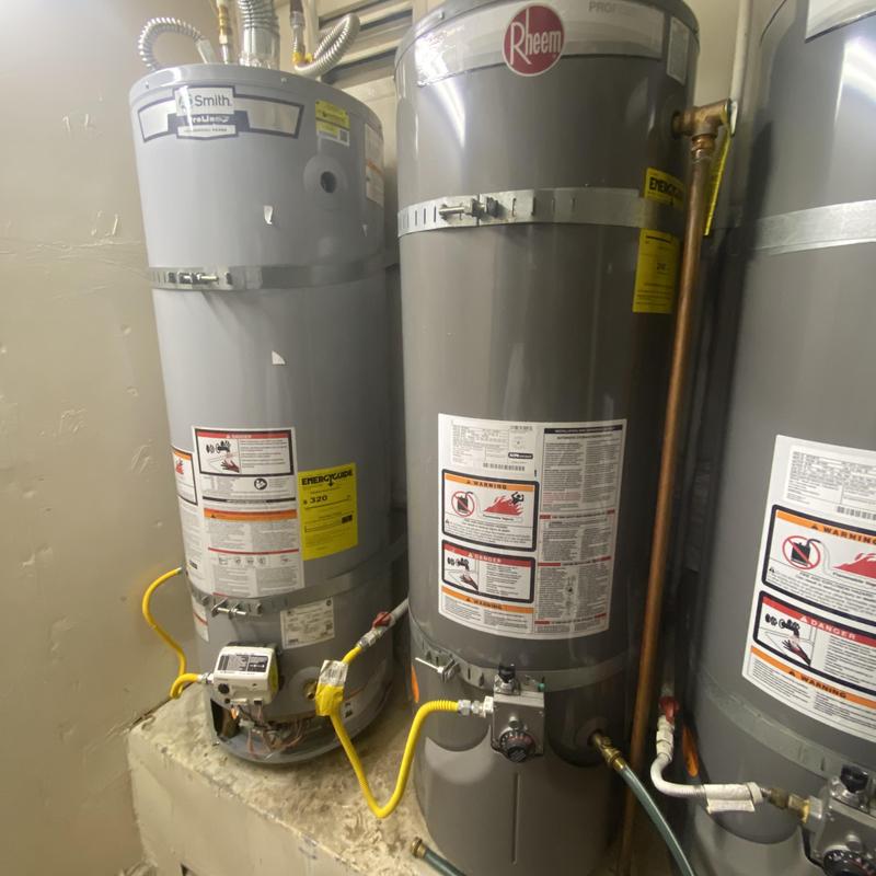 Water heater tanks with plumbing connections and labels