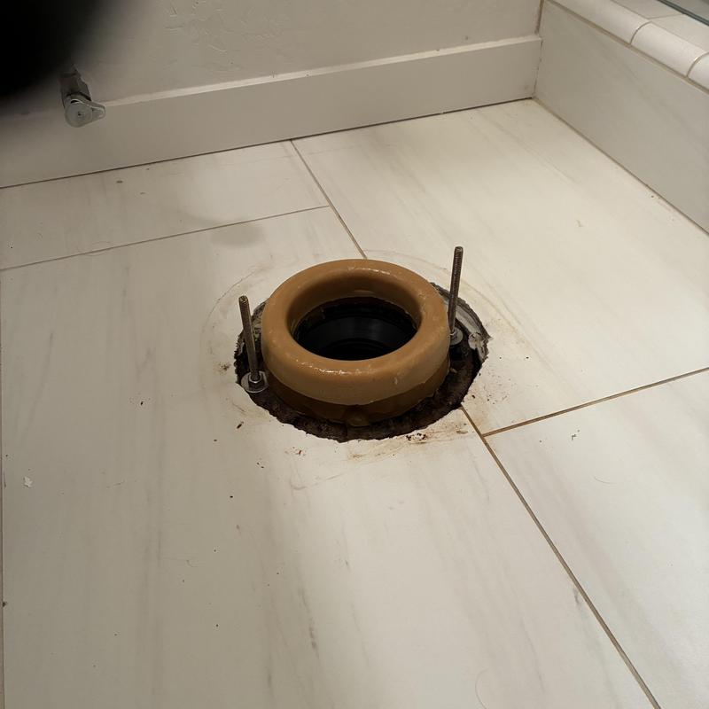 Toilet flange with new wax ring installed on tile floor