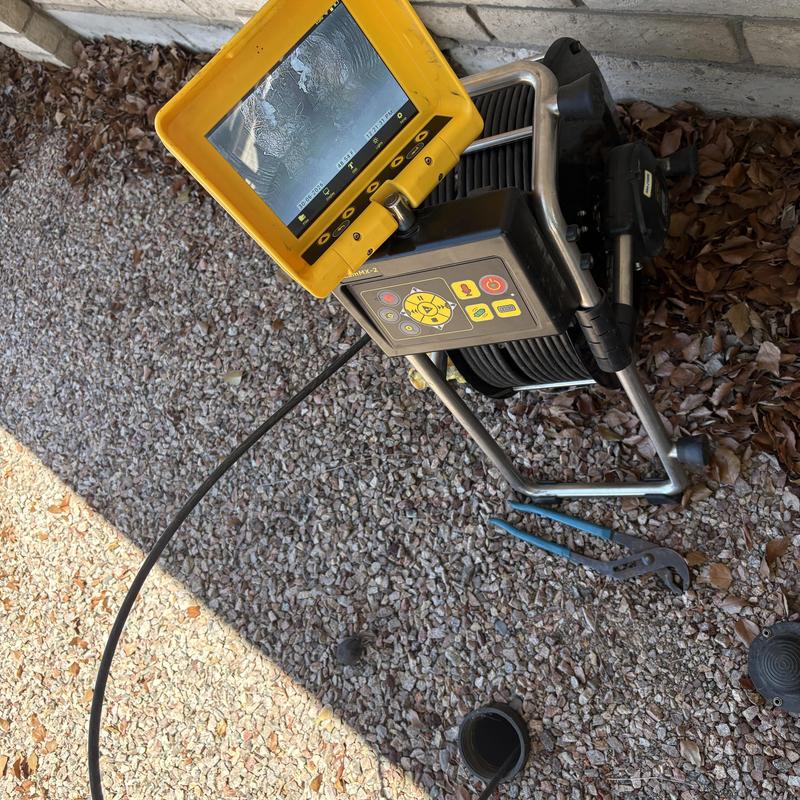 Drain inspection camera with monitor on gravel surface