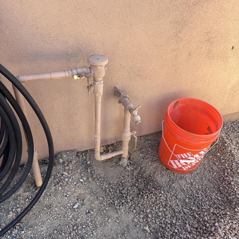 Main water entry pipe with valve and bucket outdoors