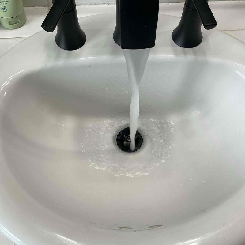 Pop-up drain assembly with black faucet running water