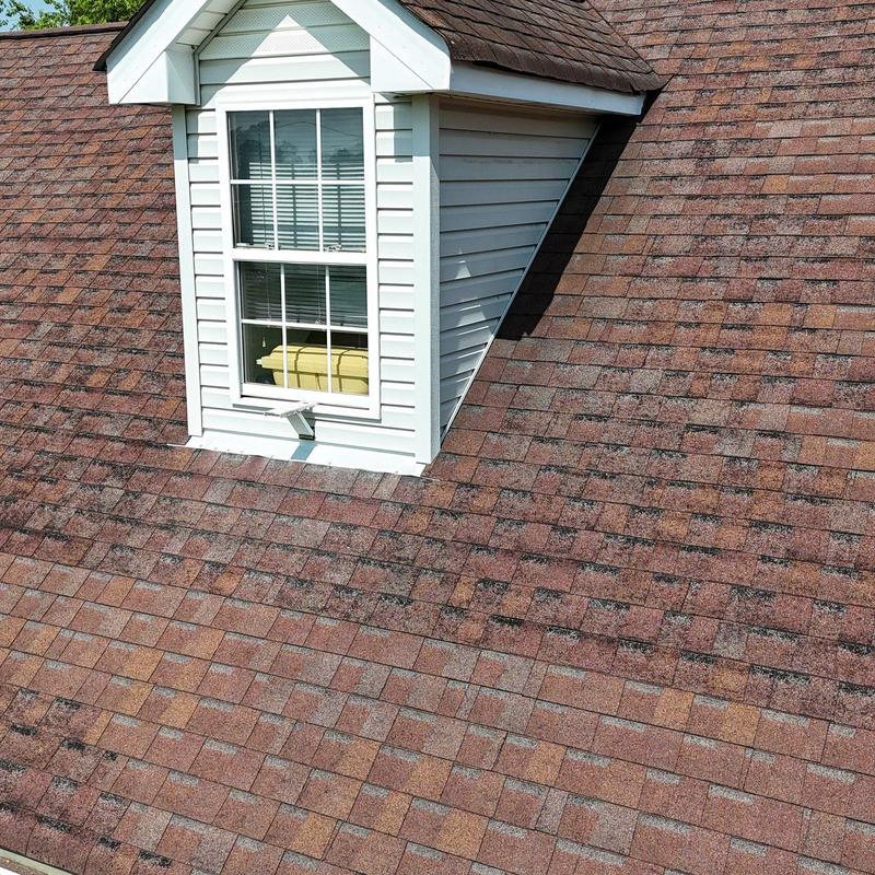 Asphalt shingle roof with granule loss near dormer window