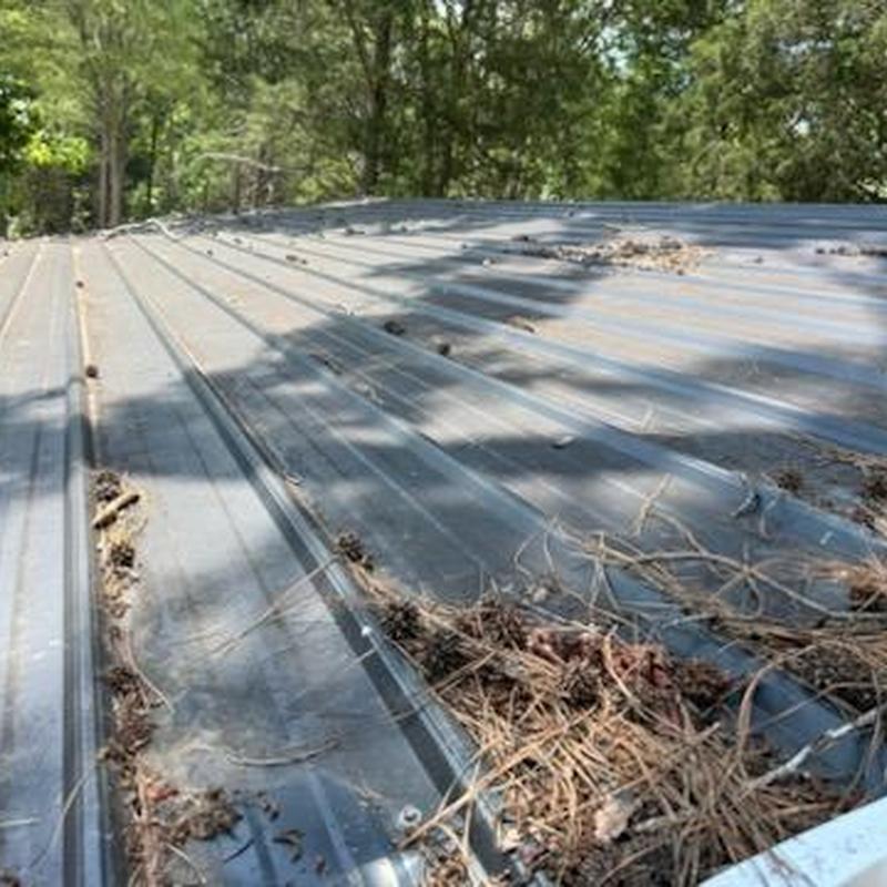 Metal roof panels with storm debris and damage Metal roof panels with storm debris and damage
