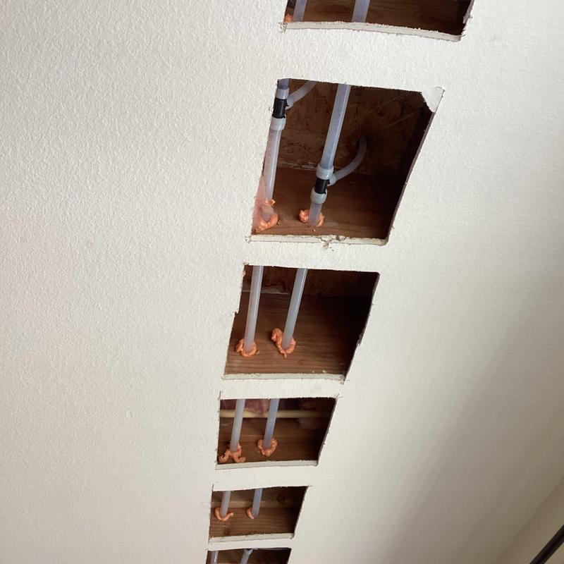 PEX plumbing pipes in ceiling cavity access holes