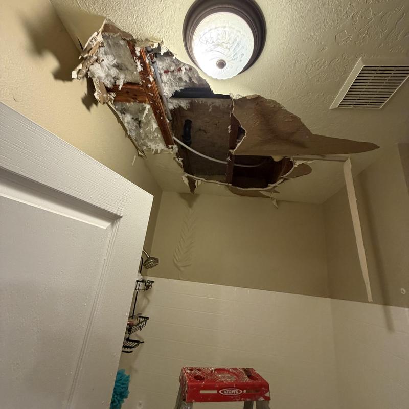 Bathroom ceiling with water damage and hole exposed Bathroom ceiling with water damage and hole exposed
