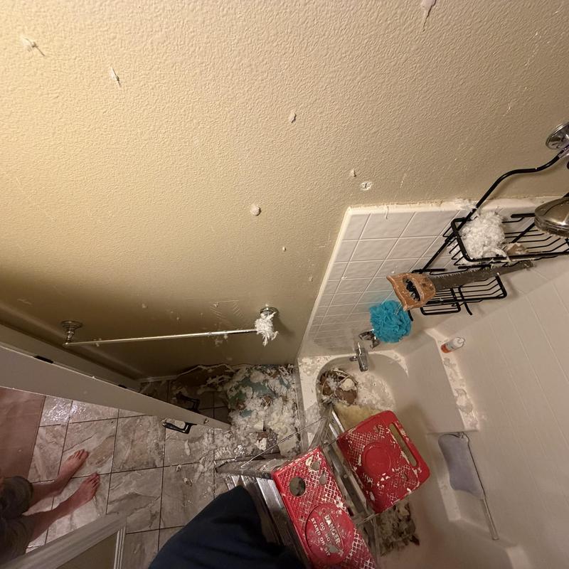 Bathroom ceiling water damage with debris and shower area Bathroom ceiling water damage with debris and shower area