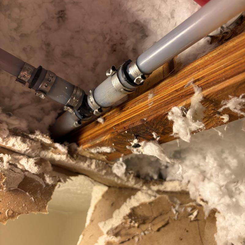 PEX water piping with metal repair clamps in attic space PEX water piping with metal repair clamps in attic space