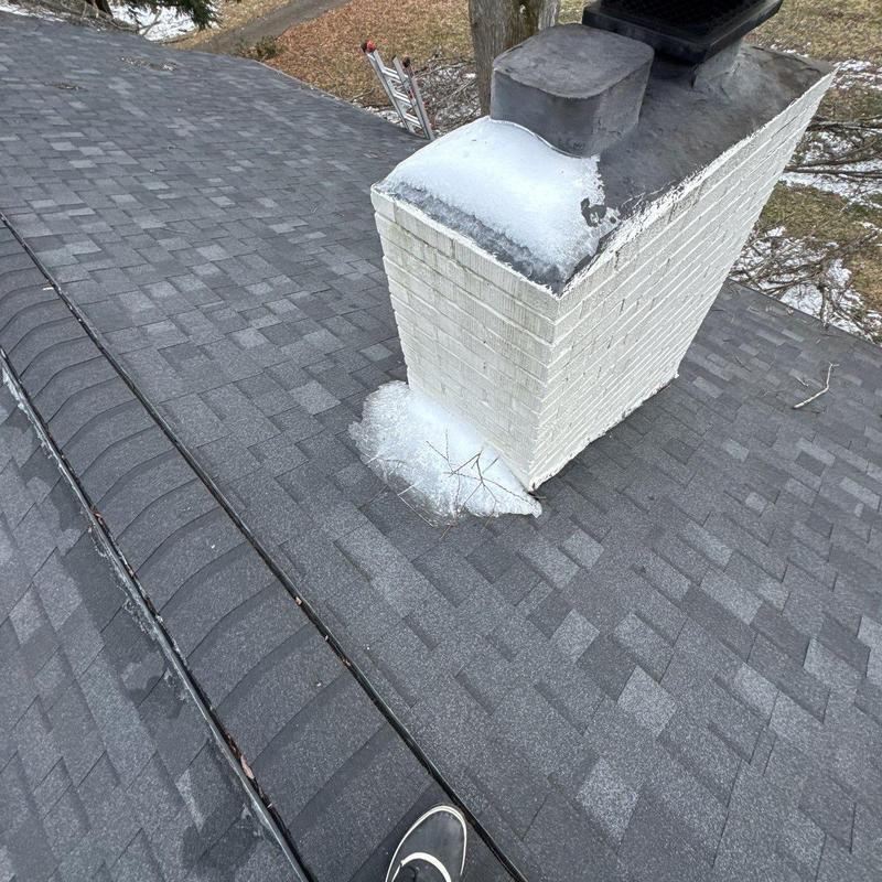 Roof shingles and chimney flashing with snow buildup