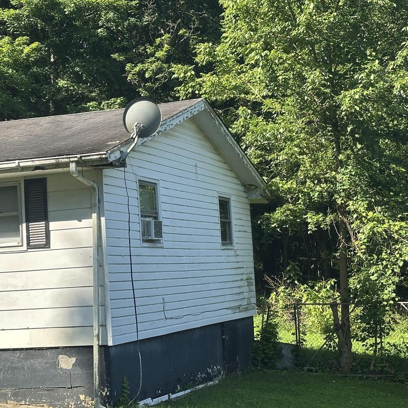 Asphalt shingle roof on older residential home exterior Asphalt shingle roof on older residential home exterior
