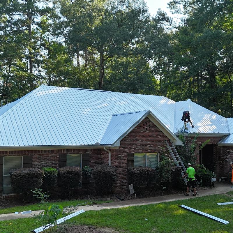 Metal roof panels installation on brick house