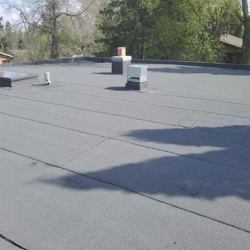 Flat roof surface with vents and chimney in daylight Flat roof surface with vents and chimney in daylight