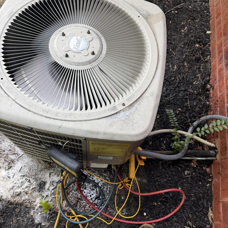 Outdoor AC unit with capacitor and gauge hoses attached Outdoor AC unit with capacitor and gauge hoses attached