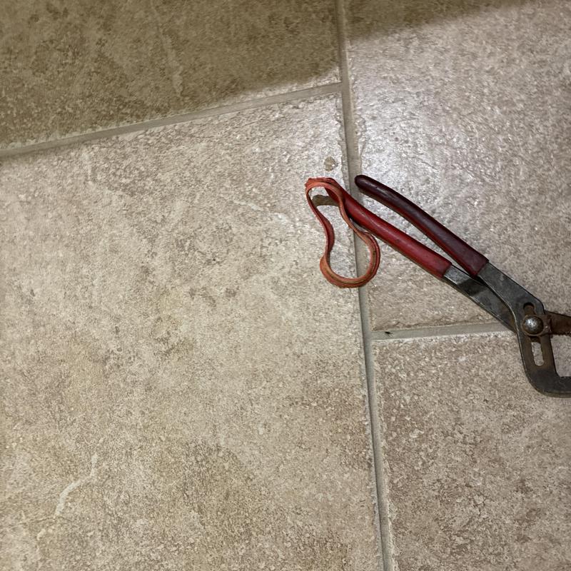 Toilet flapper valve with pliers on tiled floor Toilet flapper valve with pliers on tiled floor