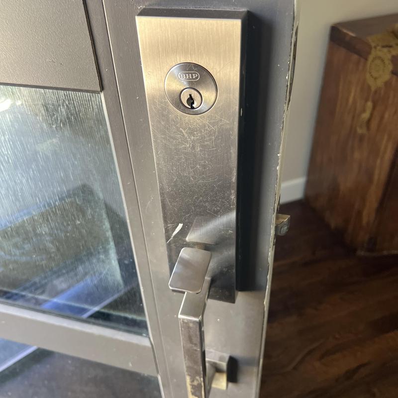 Door handle lock rekeying on metal frame door