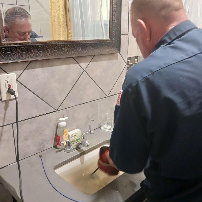 Bathroom sink drain snaking with plumber tool
