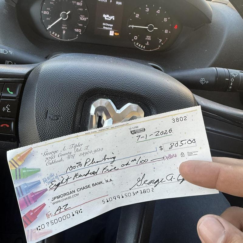 Plumbing service payment check inside vehicle steering wheel