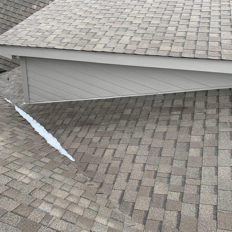 Asphalt shingle roof with hail damage and sealant line