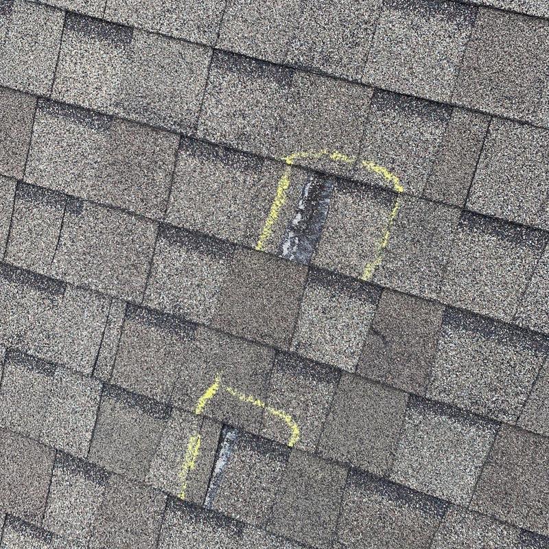 Roof shingles with hail damage marked in yellow chalk