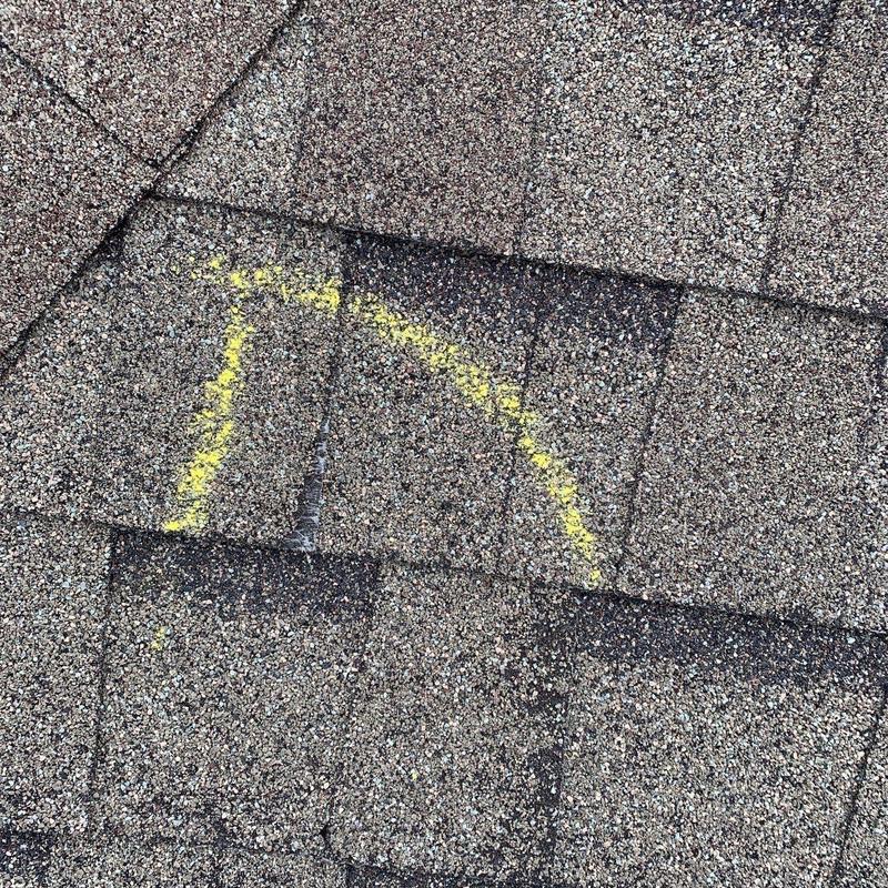 Asphalt shingles with yellow-marked hail damage