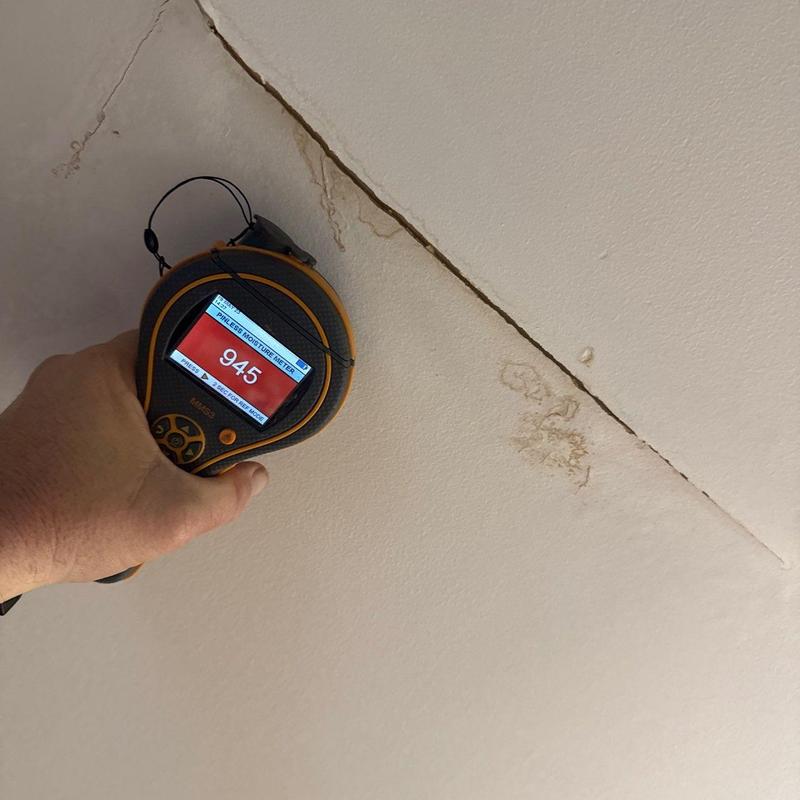 Ceiling moisture meter reading near crack and stain