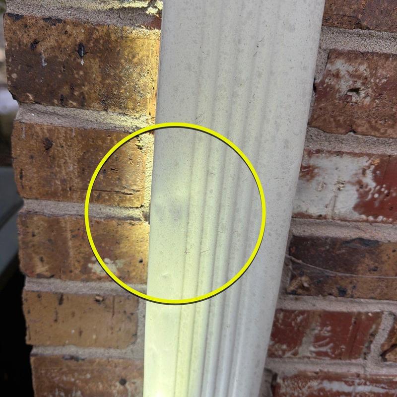 Vinyl siding damage inspection highlighted on brick wall