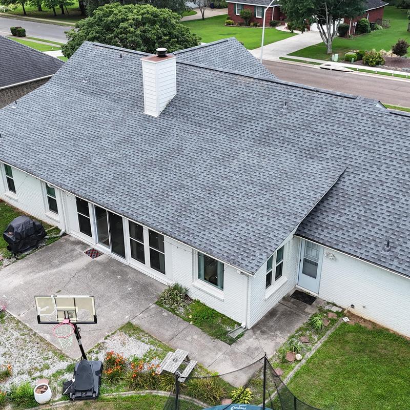 Gray asphalt shingle roof with chimney and vent pipes