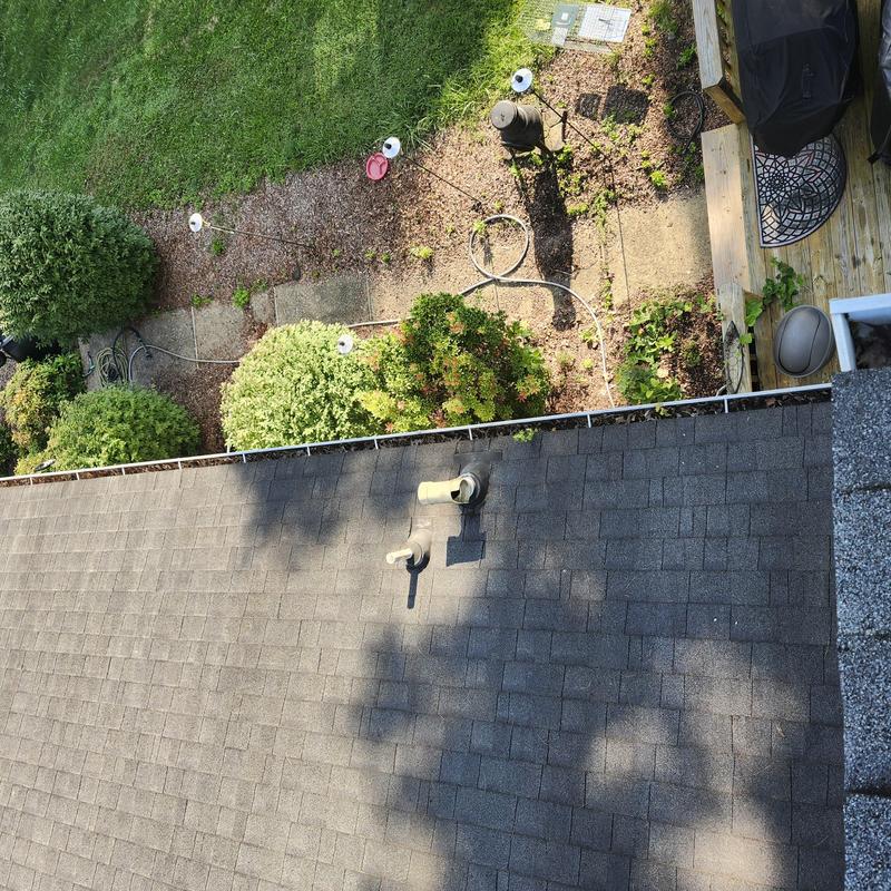 Gutter system inspection on residential roof edge Gutter system inspection on residential roof edge